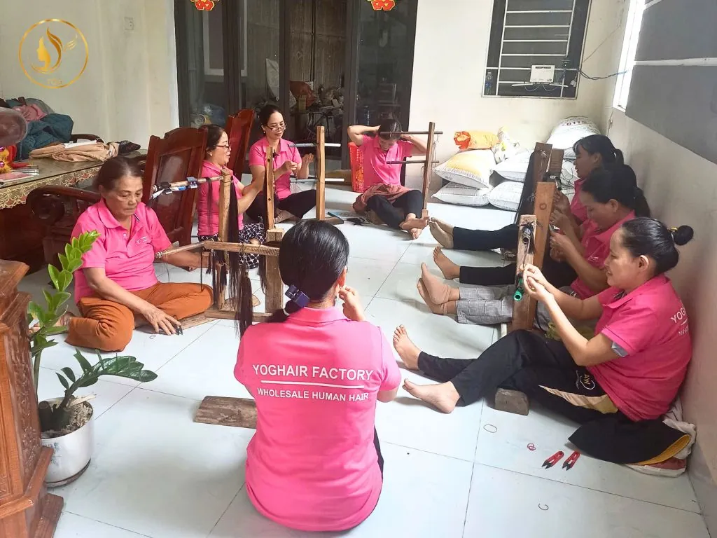 Vietnamese women working at a small-scale hair factory, manually sorting and preparing raw Vietnamese hair for export